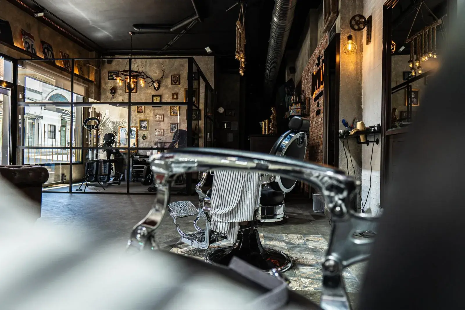 Sillón de barbero cromado y espejo con luz cálida
