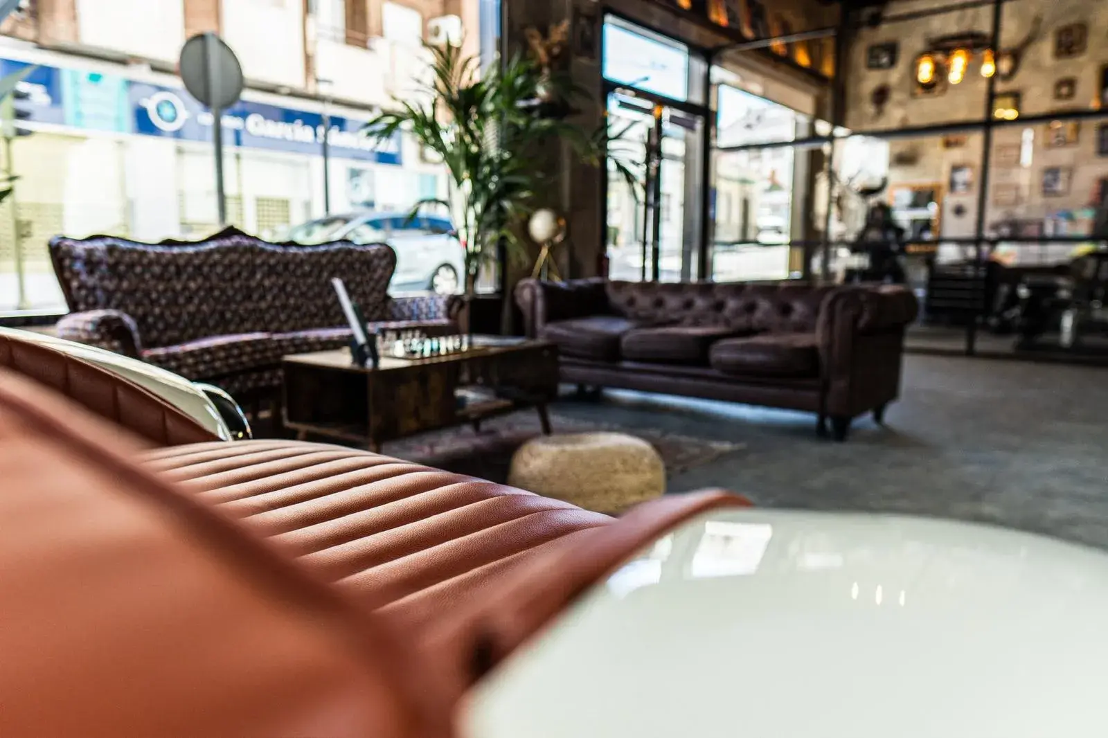 Zona de descanso con sofás de cuero y sillón de barbero en primer plano