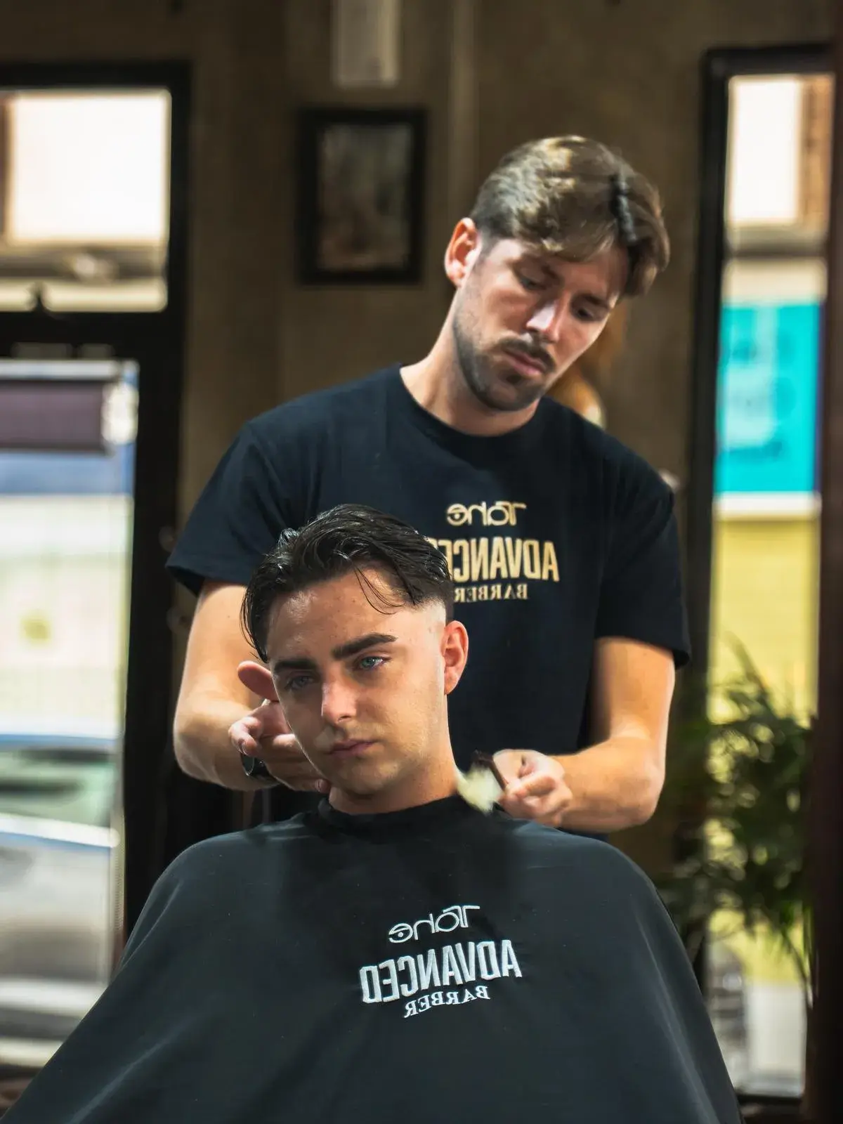 Barbero realizando un corte de pelo a un cliente en Culture