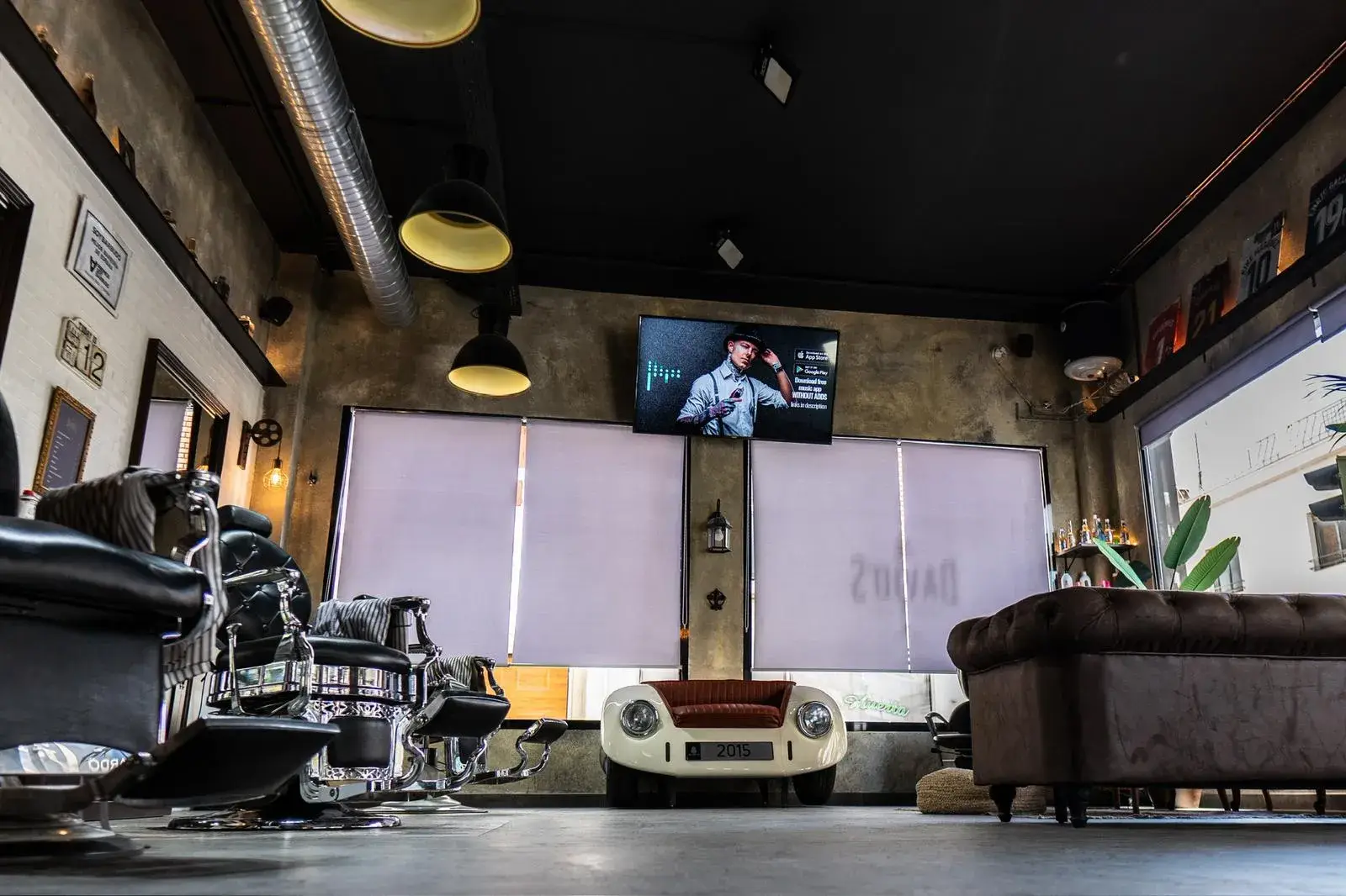 Sillones de barbero clásicos y coche vintage en el interior de la barbería