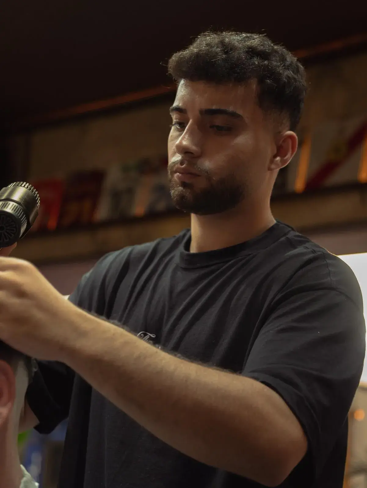 Barbero secando y peinando el pelo de un cliente