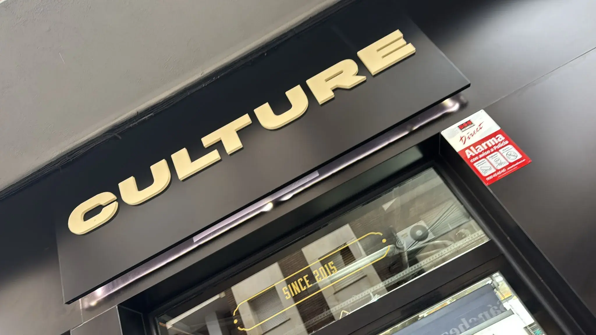 Rótulo dorado de Culture en la fachada de la barbería