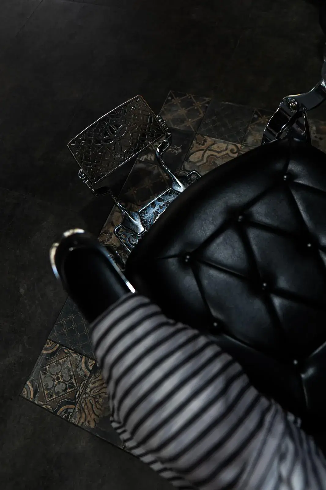 Detalle del sillón de barbero de cuero negro capitoné